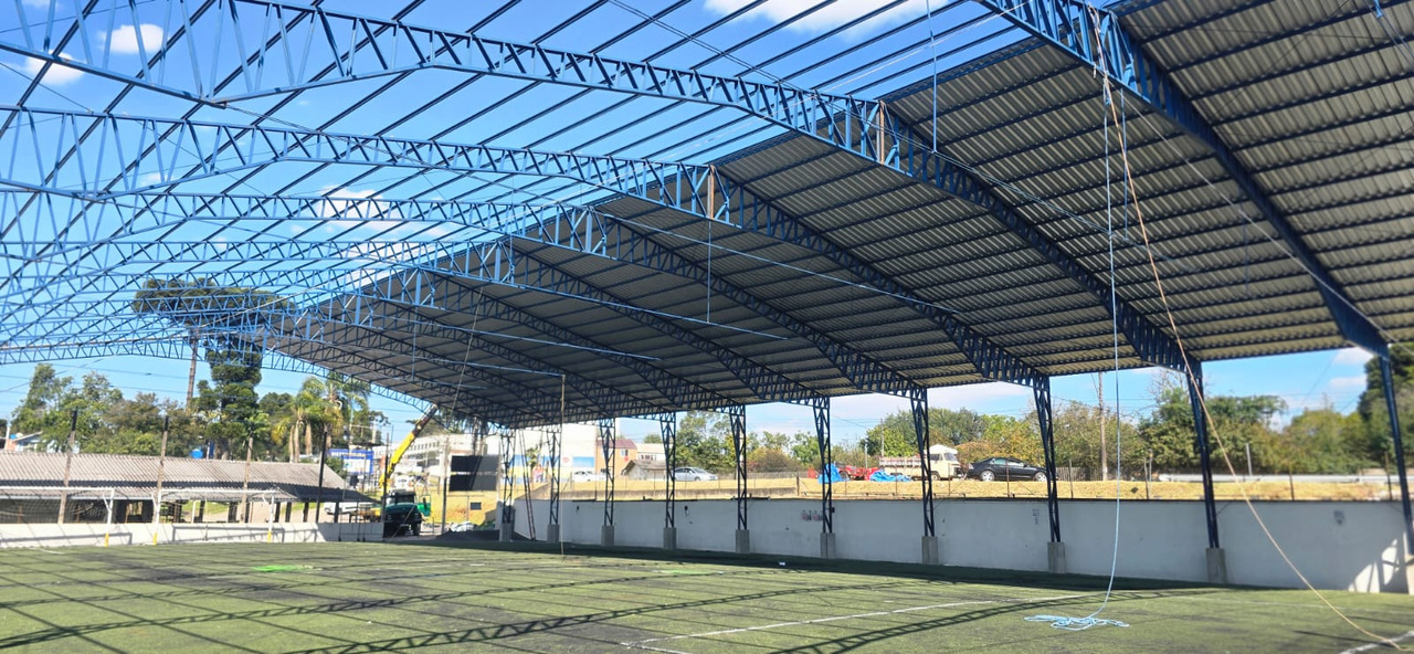 Cobertura metálica de quadra esportiva com tesouras azuis executada pela MWL em Almirante Tamandaré/PR